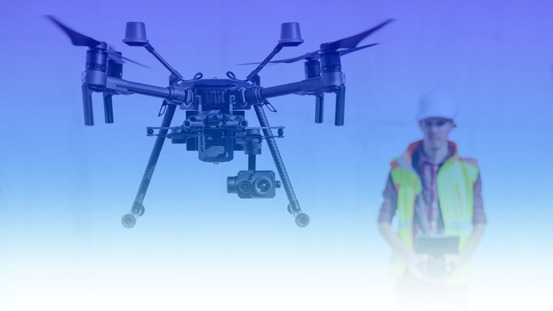 Dron profesional en vuelo junto a un operador durante la formación