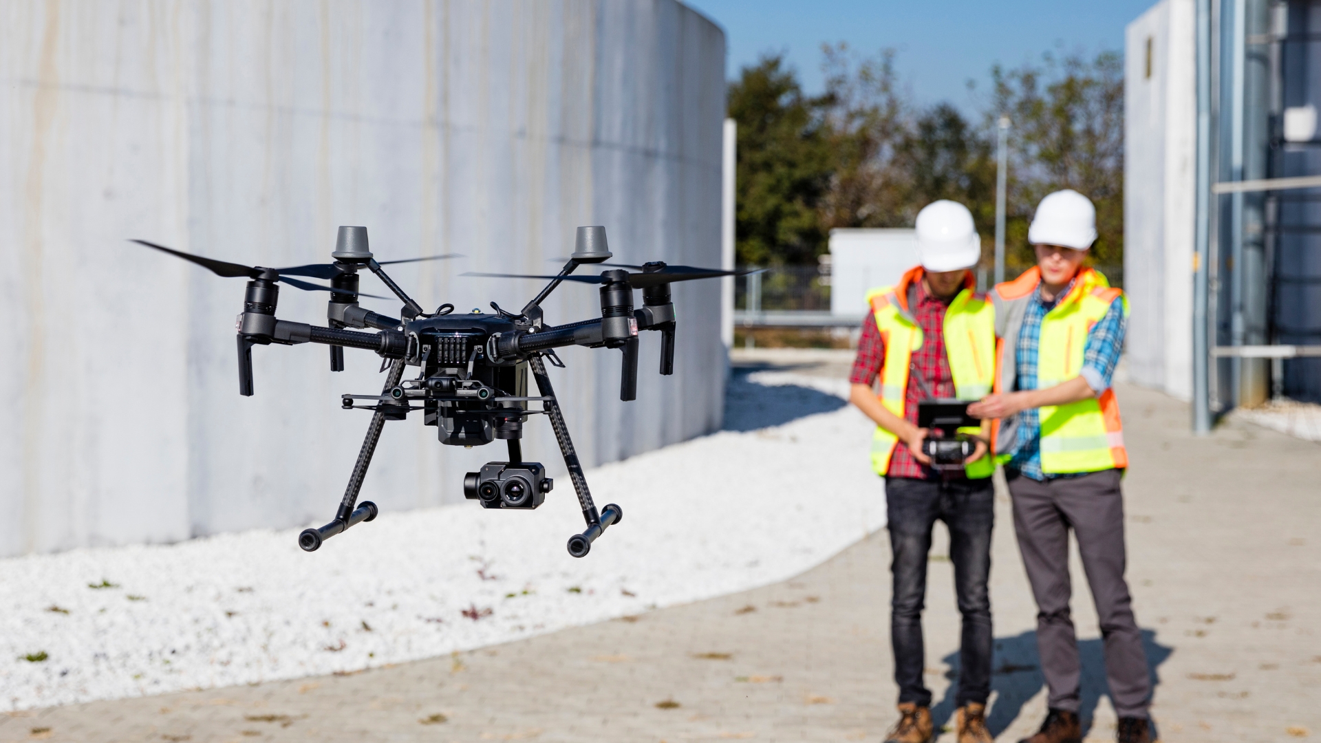 Pilotos operando un dron profesional en una instalación industrial